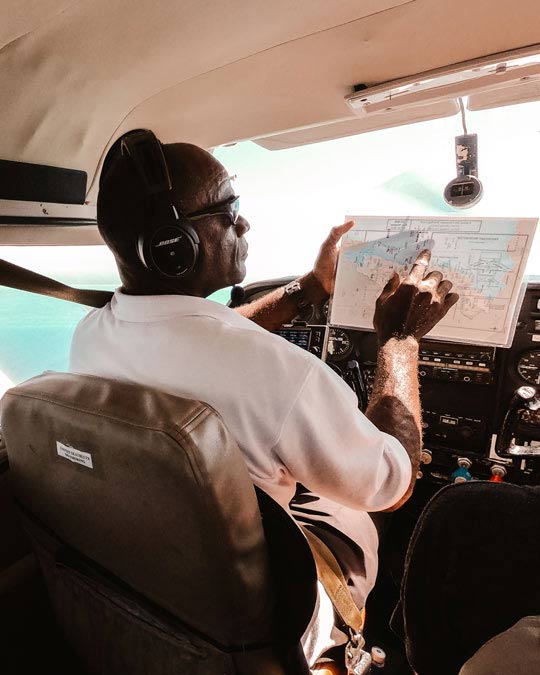 Unser Pilot beim Panoramaflug in Caye Caulker über dem Blue Hole in Belize erklärt uns unsere Route und was wir über dem schönen Riff vor Belize sehen werden.