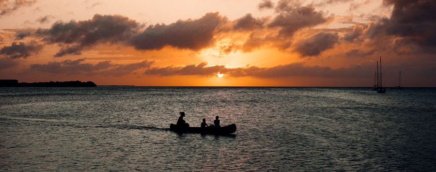 Familie beim Kayakfahren bei Sonnenuntergang vor der Küste von Caye Caulker